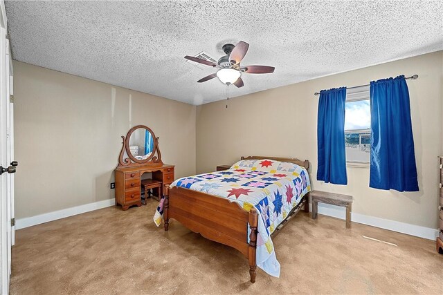 carpeted bedroom featuring ceiling fan and a textured ceiling