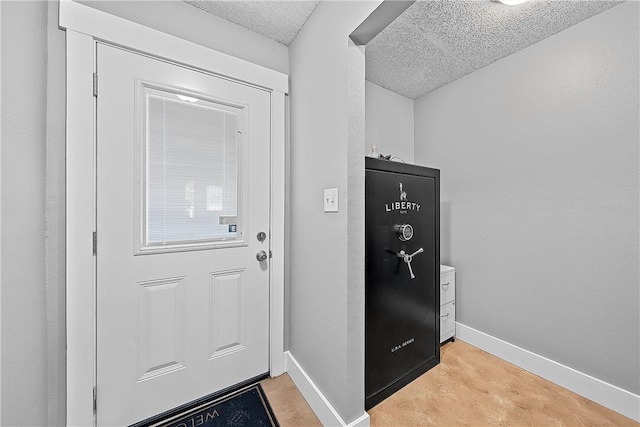 entryway with light colored carpet and a textured ceiling