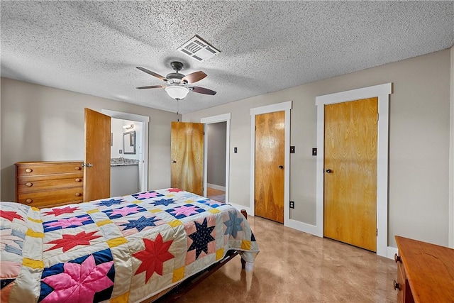 bedroom featuring ensuite bathroom, ceiling fan, and a textured ceiling