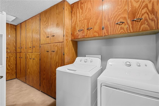 laundry area featuring cabinets, independent washer and dryer, a textured ceiling, and light colored carpet