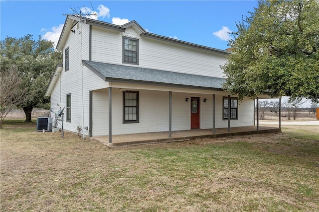 view of front of property with a front lawn, a patio, and central AC unit