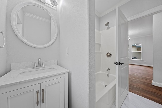 bathroom featuring ornamental molding, tub / shower combination, wood-type flooring, and vanity