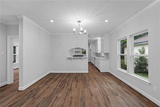 unfurnished living room featuring crown molding, wood-type flooring, and a chandelier