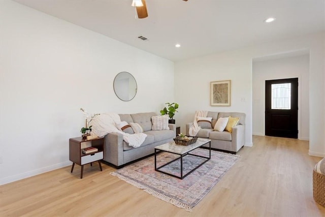 living room with light hardwood / wood-style floors and ceiling fan