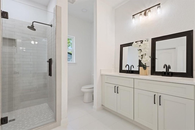 bathroom with tile patterned floors, a shower with door, vanity, and toilet