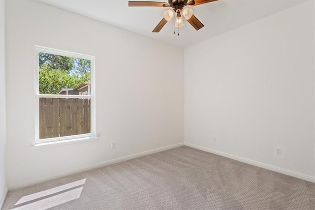 carpeted spare room with ceiling fan