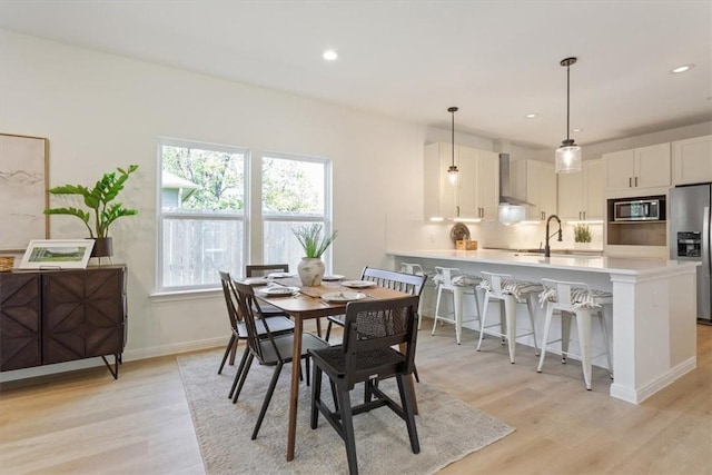 dining room featuring sink and light hardwood / wood-style flooring