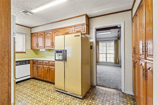 kitchen with white appliances, a textured ceiling, light carpet, and ornamental molding