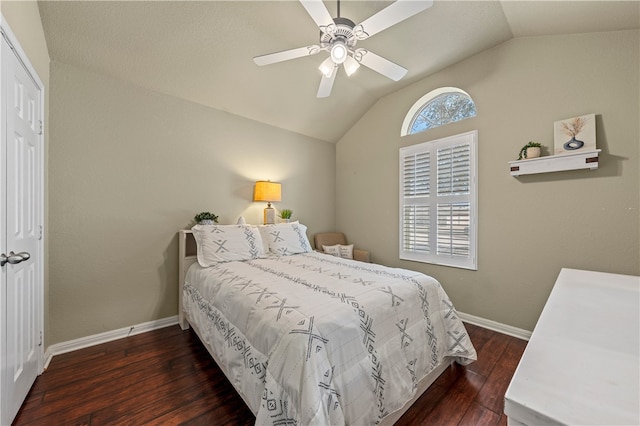 bedroom featuring baseboards, lofted ceiling, wood finished floors, a closet, and a ceiling fan