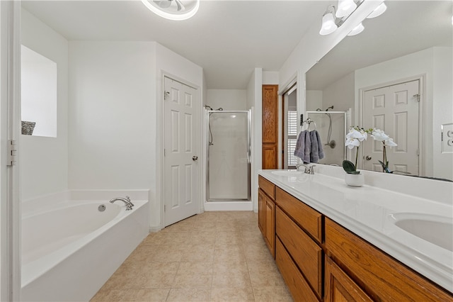 bathroom with tile patterned flooring, a shower stall, a garden tub, double vanity, and a sink