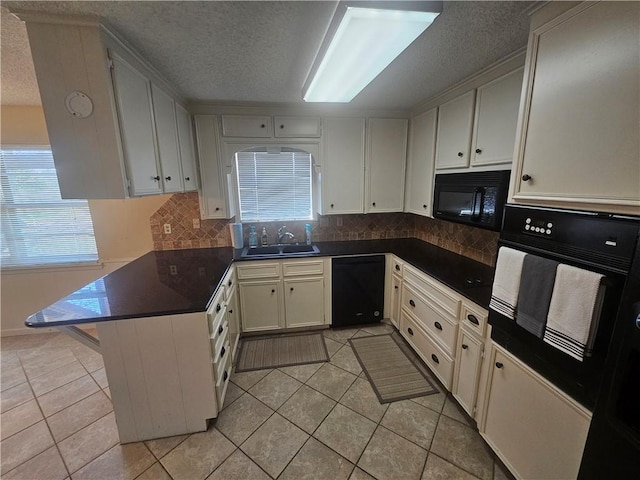 kitchen with light tile patterned floors, black appliances, dark countertops, and a sink