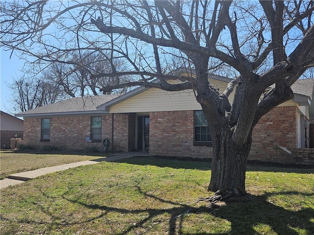 ranch-style home with a front yard and brick siding