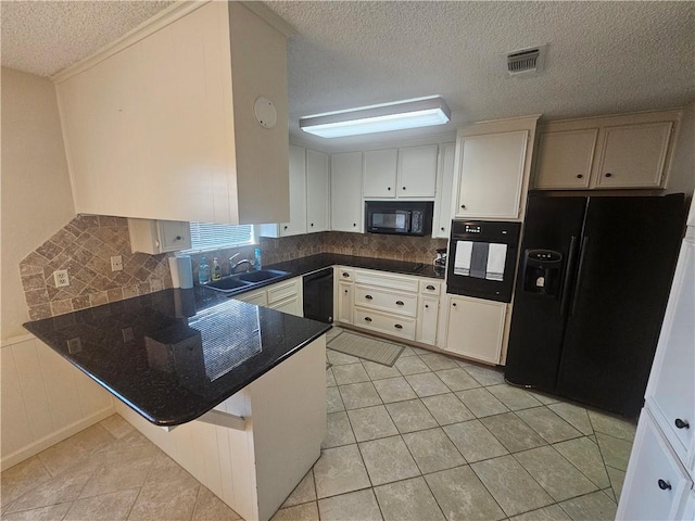 kitchen featuring light tile patterned flooring, a peninsula, a sink, visible vents, and black appliances