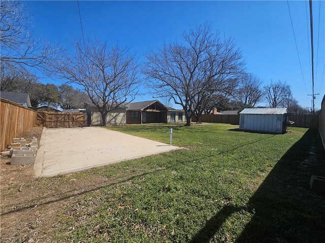 view of yard featuring a patio area, a fenced backyard, a storage unit, and an outdoor structure