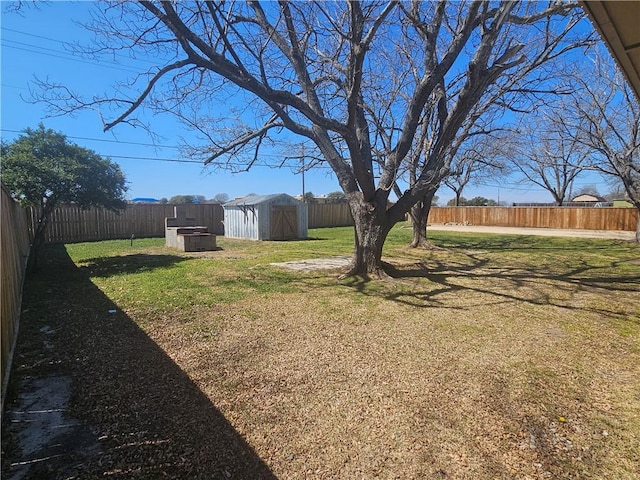 view of yard featuring a shed, a fenced backyard, and an outdoor structure