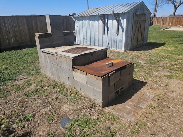 view of storm shelter with a yard, a shed, a fenced backyard, and an outdoor structure