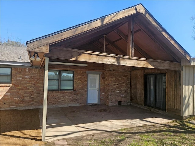 rear view of property with brick siding and crawl space