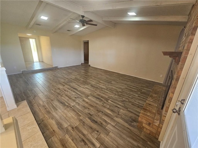 interior space featuring vaulted ceiling with beams, visible vents, wood finished floors, and a ceiling fan