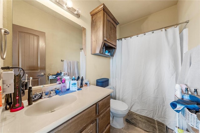 bathroom with toilet, tile patterned floors, and vanity