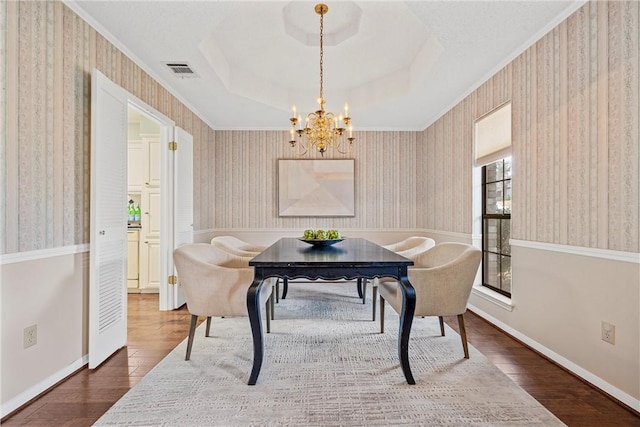 dining room with wallpapered walls, visible vents, and wood finished floors