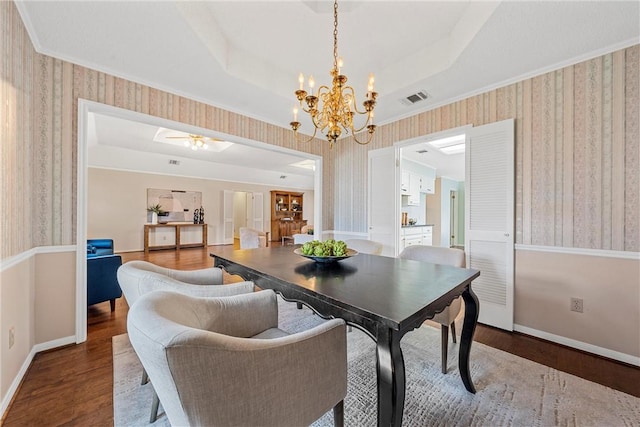 dining room featuring a tray ceiling and wallpapered walls