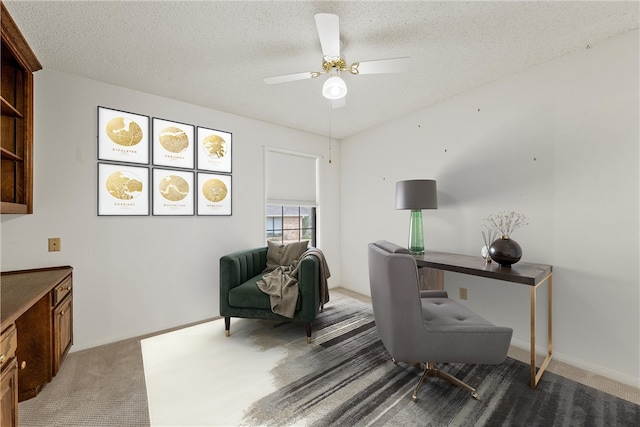 office featuring light carpet, ceiling fan, baseboards, and a textured ceiling