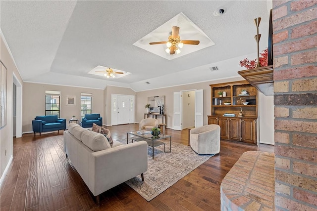 living room featuring dark wood-style floors, visible vents, a ceiling fan, and a textured ceiling