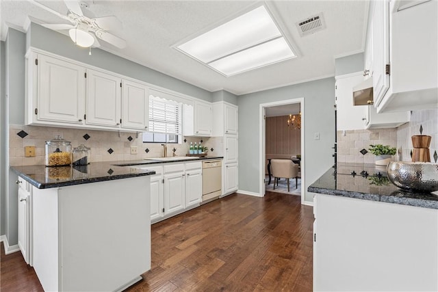 kitchen with white cabinets, dishwasher, dark stone counters, dark wood-style flooring, and a sink