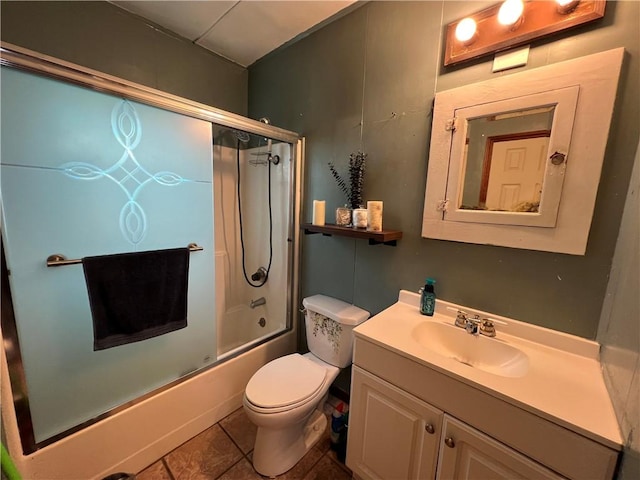 full bath featuring tile patterned flooring, combined bath / shower with glass door, vanity, and toilet