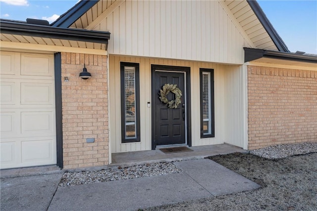 entrance to property with an attached garage and brick siding