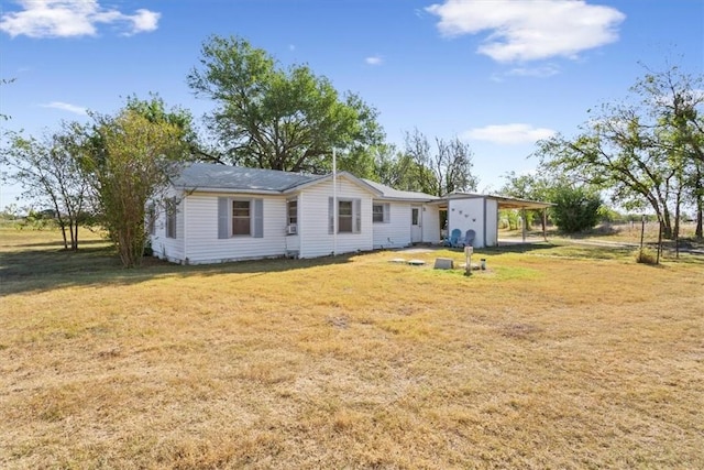 rear view of property with a yard and a carport