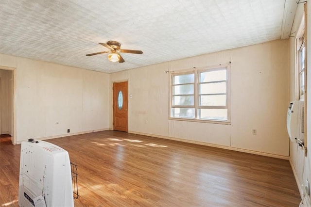 unfurnished room with hardwood / wood-style flooring, ceiling fan, and heating unit