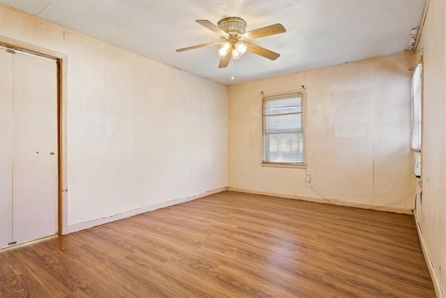 empty room with ceiling fan and light wood-type flooring