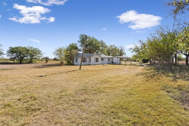 view of yard featuring a carport and a rural view