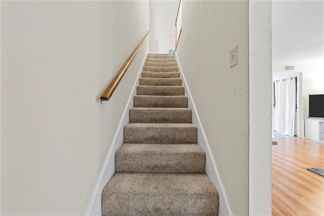 stairs featuring wood-type flooring