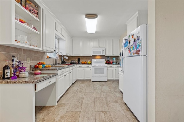 kitchen featuring white appliances, sink, decorative backsplash, dark stone countertops, and white cabinetry