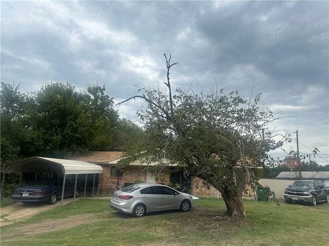 obstructed view of property with a carport and a front lawn