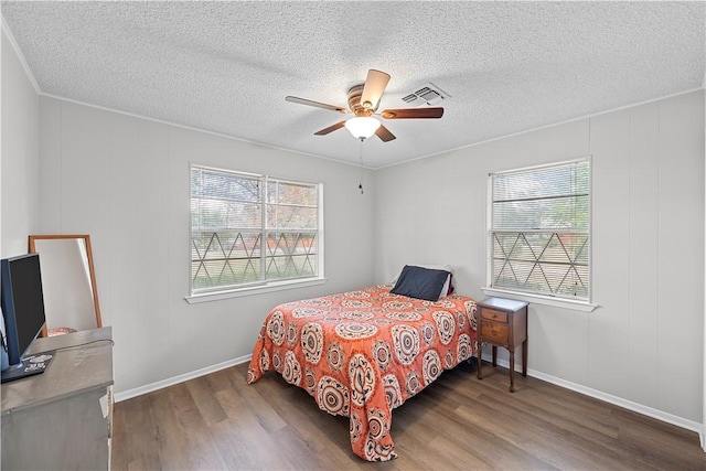 bedroom with ceiling fan, dark hardwood / wood-style flooring, crown molding, and a textured ceiling