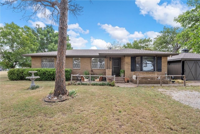 ranch-style home featuring a shed and a front yard