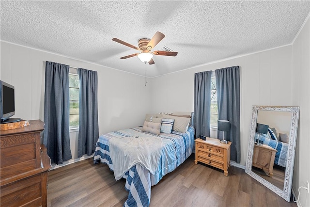 bedroom with multiple windows, a textured ceiling, dark hardwood / wood-style floors, and ceiling fan