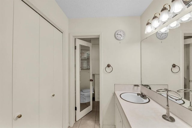 bathroom featuring tile patterned floors, vanity, and a textured ceiling