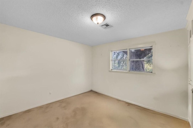 carpeted spare room featuring a textured ceiling