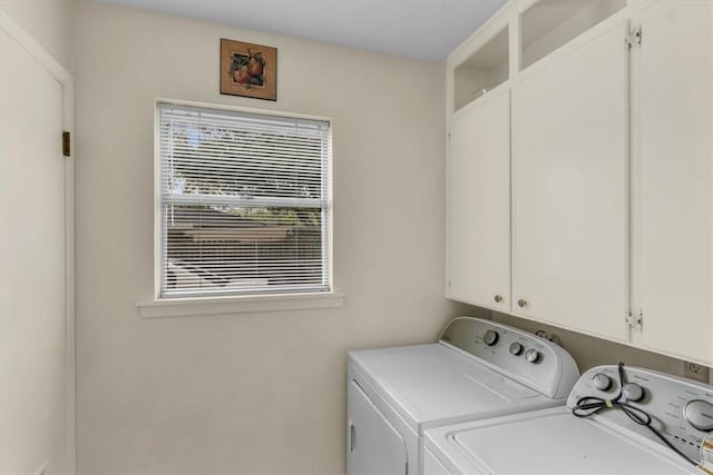 washroom featuring cabinets and separate washer and dryer