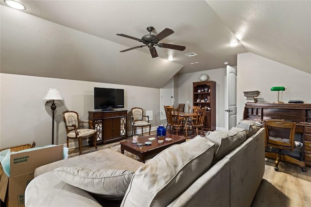 living room with lofted ceiling, ceiling fan, visible vents, baseboards, and light wood-style floors