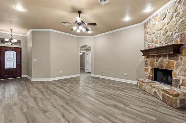 dining room featuring arched walkways, light wood finished floors, lofted ceiling, ornamental molding, and baseboards