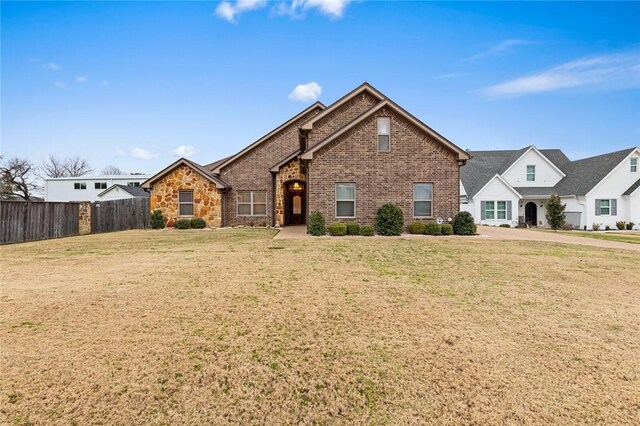 entrance to property featuring stone siding, brick siding, and a yard