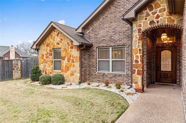 rear view of house with brick siding, a yard, fence, and a patio