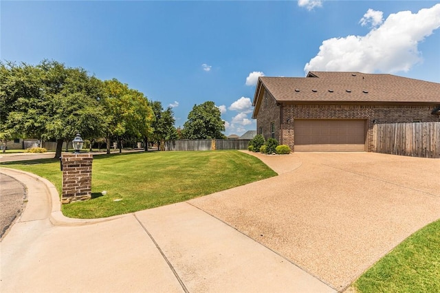 exterior space with concrete driveway, brick siding, a lawn, and fence