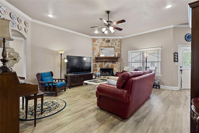 living area with light wood-style flooring, a fireplace, baseboards, and crown molding