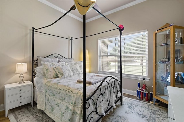 bedroom featuring ornamental molding, light wood-style floors, and baseboards